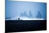 Tourist running on Black Sand Beach, Iceland, Polar Regions-John Alexander-Mounted Photographic Print