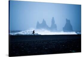 Tourist running on Black Sand Beach, Iceland, Polar Regions-John Alexander-Stretched Canvas