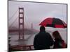 Tourists Use an Umbrella During a Light Rain, Looking at the Golden Gate Bridge in San Francisco-null-Mounted Photographic Print