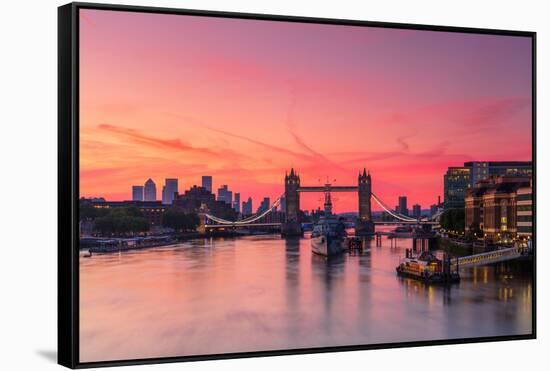 Tower Bridge, River Thames and HMS Belfast at sunrise with pink sky, and Canary Wharf-Ed Hasler-Framed Stretched Canvas