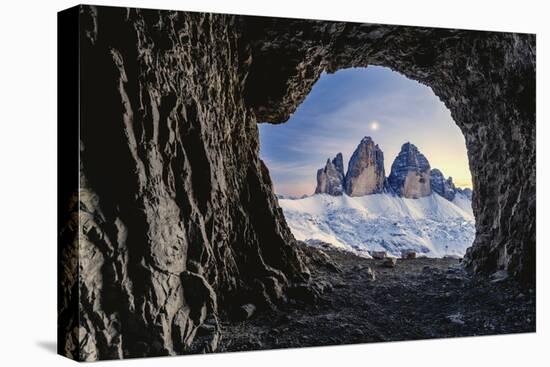 Tre Cime di Lavaredo lit by moon seen from opening in rocks of a war cave, Sesto Dolomites-Roberto Moiola-Stretched Canvas