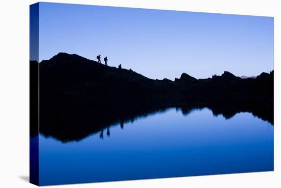 Trekkers are Reflected in the Cool Waters of Chilata Lagoon Outside the Town of Sorata, Bolivia-Sergio Ballivian-Stretched Canvas