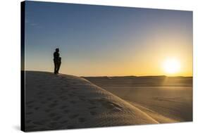 Tuareg standing on a sand dune in the Tenere Desert at sunrise, Sahara, Niger, Africa-Michael Runkel-Stretched Canvas