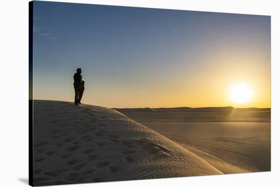 Tuareg standing on a sand dune in the Tenere Desert at sunrise, Sahara, Niger, Africa-Michael Runkel-Stretched Canvas