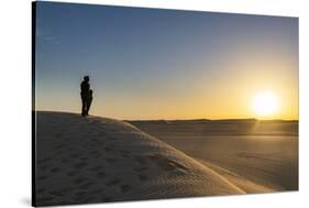 Tuareg standing on a sand dune in the Tenere Desert at sunrise, Sahara, Niger, Africa-Michael Runkel-Stretched Canvas