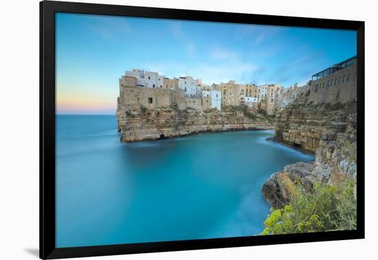 Turquoise sea at sunset framed by the old town perched on the rocks, Polignano a Mare, Province of -Roberto Moiola-Framed Photographic Print