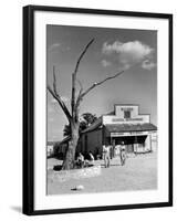 Two Boys Playing Nr. a Dead Tree as Judge Roy Langrty and a Man Walk Past a General Store-Alfred Eisenstaedt-Framed Photographic Print