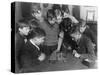 Two Boys Sit for a Game of Chess. Eight Spectators Look On-null-Stretched Canvas