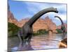 Two Brachiosaurus Dinosaurs in Water Next to Red Rock Mountains-null-Mounted Art Print