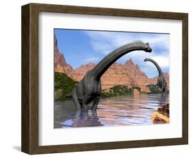 Two Brachiosaurus Dinosaurs in Water Next to Red Rock Mountains-null-Framed Art Print