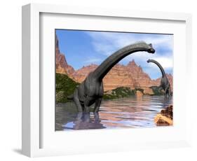 Two Brachiosaurus Dinosaurs in Water Next to Red Rock Mountains-null-Framed Art Print