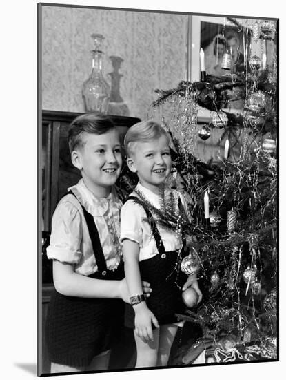 Two Brothers Look at a Christmas Tree in their Living Room in Germany, Ca. 1949-null-Mounted Photographic Print