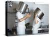 Two Chefs Having Discussion with Large Pans on their Heads-Robert Kneschke-Stretched Canvas