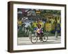 Two Children Ride Their Bicycle Pass a Mural-null-Framed Photographic Print