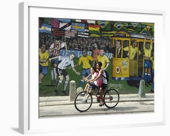 Two Children Ride Their Bicycle Pass a Mural-null-Framed Photographic Print