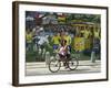 Two Children Ride Their Bicycle Pass a Mural-null-Framed Photographic Print