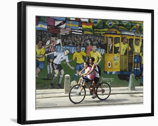Two Children Ride Their Bicycle Pass a Mural-null-Framed Photographic Print