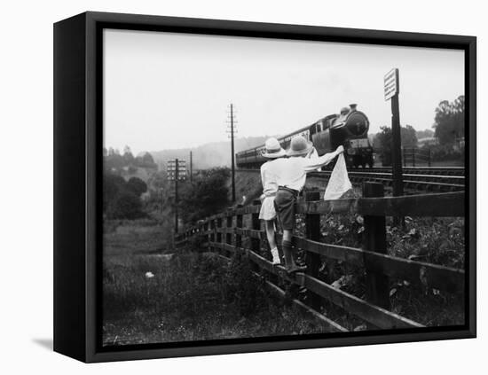 Two Children Stand on a Fence and Wave a Handkerchief at a Passing Steam Train-Staniland Pugh-Framed Stretched Canvas