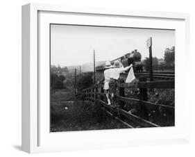 Two Children Stand on a Fence and Wave a Handkerchief at a Passing Steam Train-Staniland Pugh-Framed Photographic Print