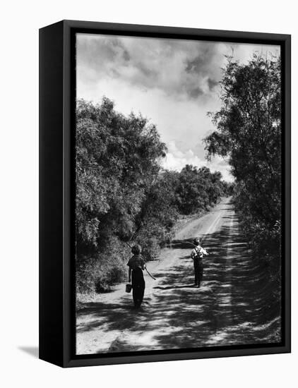 Two Children Walking Down a Dirt Road Going Fishing on a Summer Day-John Dominis-Framed Stretched Canvas