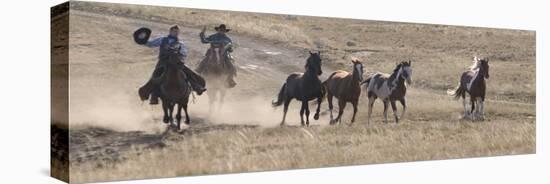 Two Cowboys Herding Horses, Flitner Ranch, Shell, Wyoming, USA-Carol Walker-Stretched Canvas