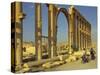 Two Cyclists Pass the Great Colonnade (Cardo), Palmyra, Unesco World Heritage Site, Syria-Eitan Simanor-Stretched Canvas