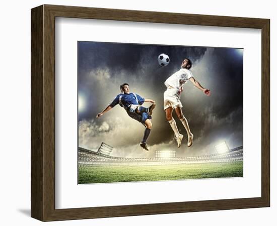Two Football Players in Jump to Strike the Ball at the Stadium-Sergey Nivens-Framed Photographic Print