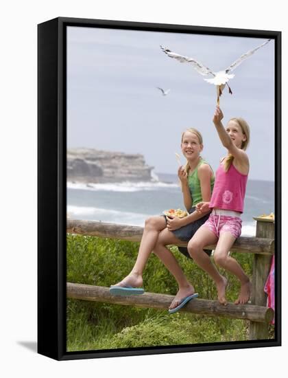 Two Girls Feeding Chips to a Seagull at the Beach-Louise Hammond-Framed Stretched Canvas