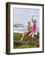 Two Girls Feeding Chips to a Seagull at the Beach-Louise Hammond-Framed Photographic Print