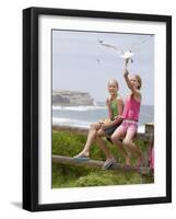 Two Girls Feeding Chips to a Seagull at the Beach-Louise Hammond-Framed Photographic Print
