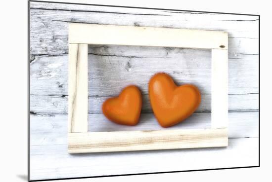 Two Hearts Made of Stone in Picture Frame-Uwe Merkel-Mounted Photographic Print