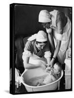 Two Nurses Bath a Baby-null-Stretched Canvas