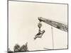 Two People Dangling from Crane-null-Mounted Photo