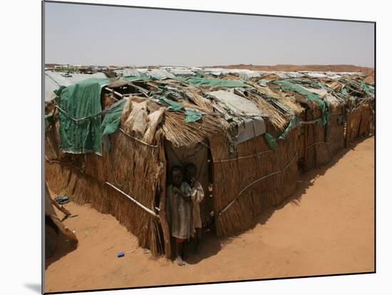 Two Sudanese Boys Stand by Makeshift Huts-null-Mounted Photographic Print