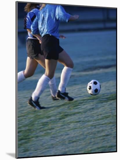 Two Teenage Girls Running for a Soccer Ball-null-Mounted Photographic Print