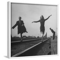 Two Young Ballet Russe Dancers Balancing on the Railroad Tracks in the Station While on Tour-Myron Davis-Framed Photographic Print