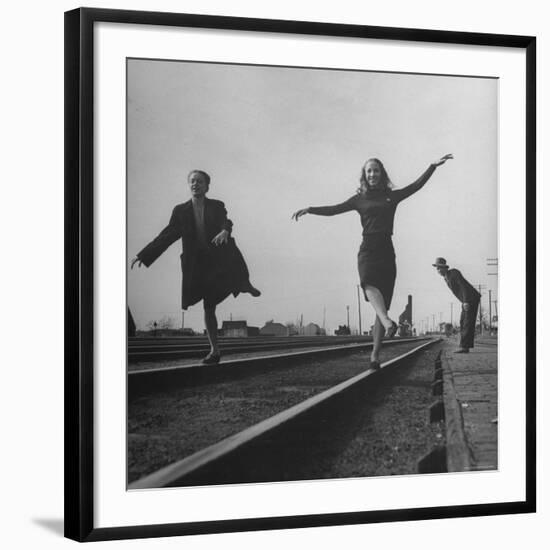 Two Young Ballet Russe Dancers Balancing on the Railroad Tracks in the Station While on Tour-Myron Davis-Framed Photographic Print