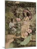 Two Young Japanese Girls, One Holding a Parasol, with Lotus Flowers-null-Mounted Photographic Print