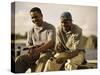 Two Young Men Sitting on The Pier Fishing-null-Stretched Canvas