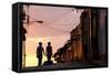 Two Young People in Silhouette at Sunset on Cobbled Street with Colourful Orange Sky Behind-Lee Frost-Framed Stretched Canvas