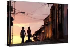 Two Young People in Silhouette at Sunset on Cobbled Street with Colourful Orange Sky Behind-Lee Frost-Stretched Canvas