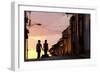 Two Young People in Silhouette at Sunset on Cobbled Street with Colourful Orange Sky Behind-Lee Frost-Framed Photographic Print