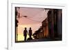 Two Young People in Silhouette at Sunset on Cobbled Street with Colourful Orange Sky Behind-Lee Frost-Framed Photographic Print