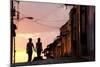 Two Young People in Silhouette at Sunset on Cobbled Street with Colourful Orange Sky Behind-Lee Frost-Mounted Photographic Print