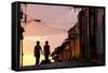 Two Young People in Silhouette at Sunset on Cobbled Street with Colourful Orange Sky Behind-Lee Frost-Framed Stretched Canvas