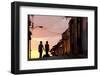 Two Young People in Silhouette at Sunset on Cobbled Street with Colourful Orange Sky Behind-Lee Frost-Framed Photographic Print