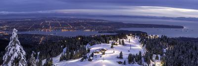 Freestyle skier doing a trick off a jump above city at sunset, Canada, North America-Tyler Lillico-Stretched Canvas