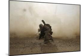 U.S. Marine Shields Himself from Dust Being Kicked Up from a Ch-53E Super Stallion-null-Mounted Photographic Print