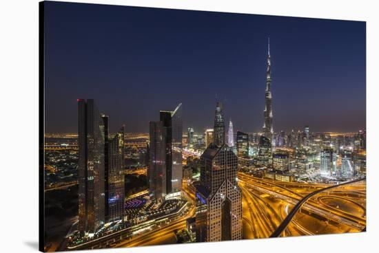 UAE, Downtown Dubai. Cityscape with Burj Khalifa at night.-Walter Bibikow-Stretched Canvas