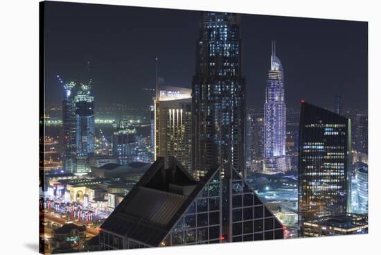 UAE, Downtown Dubai. Downtown cityscape at night lit in blue.-Walter Bibikow-Stretched Canvas